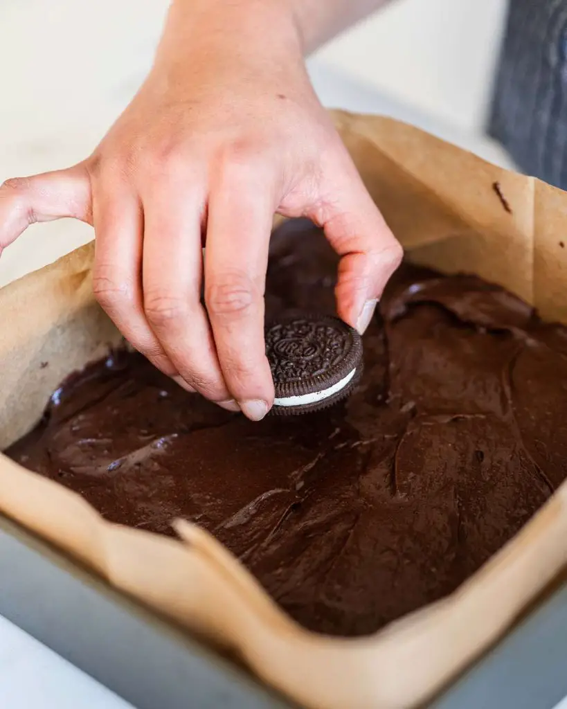 Layering the middle "stuffed" layer of biscuits in the brownie. Recipe by movers and bakers