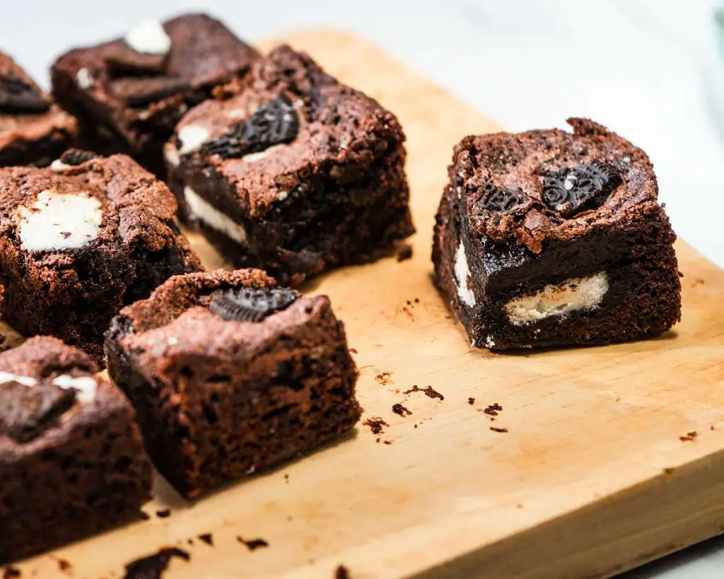Oreo stuffed brownies. Deeply dark and rich, these brownies have an Oreo layer in the middle and more broken biscuits on top. Oreo heaven! Recipe by movers and bakers