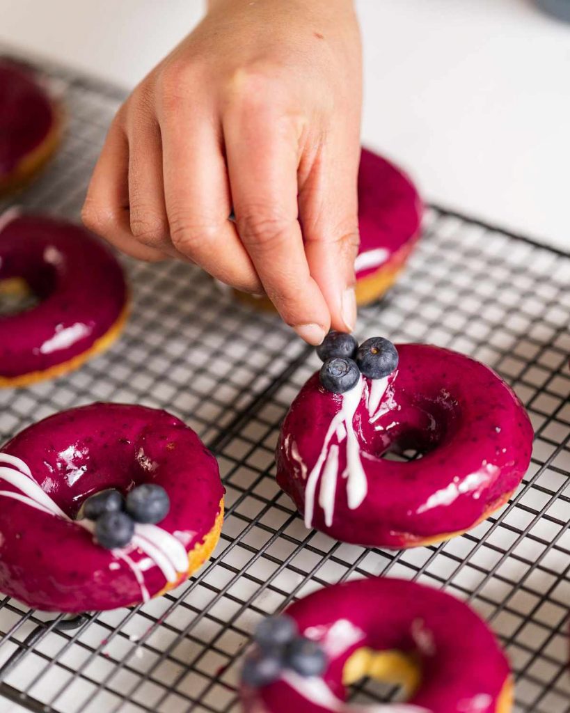 Adding the finishing touches to these amazing blueberry lemon donuts.