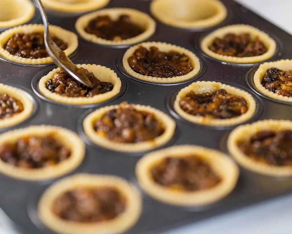 Filling the pastry shells with delicious homemade mincemeat. Recipe by movers and bakers