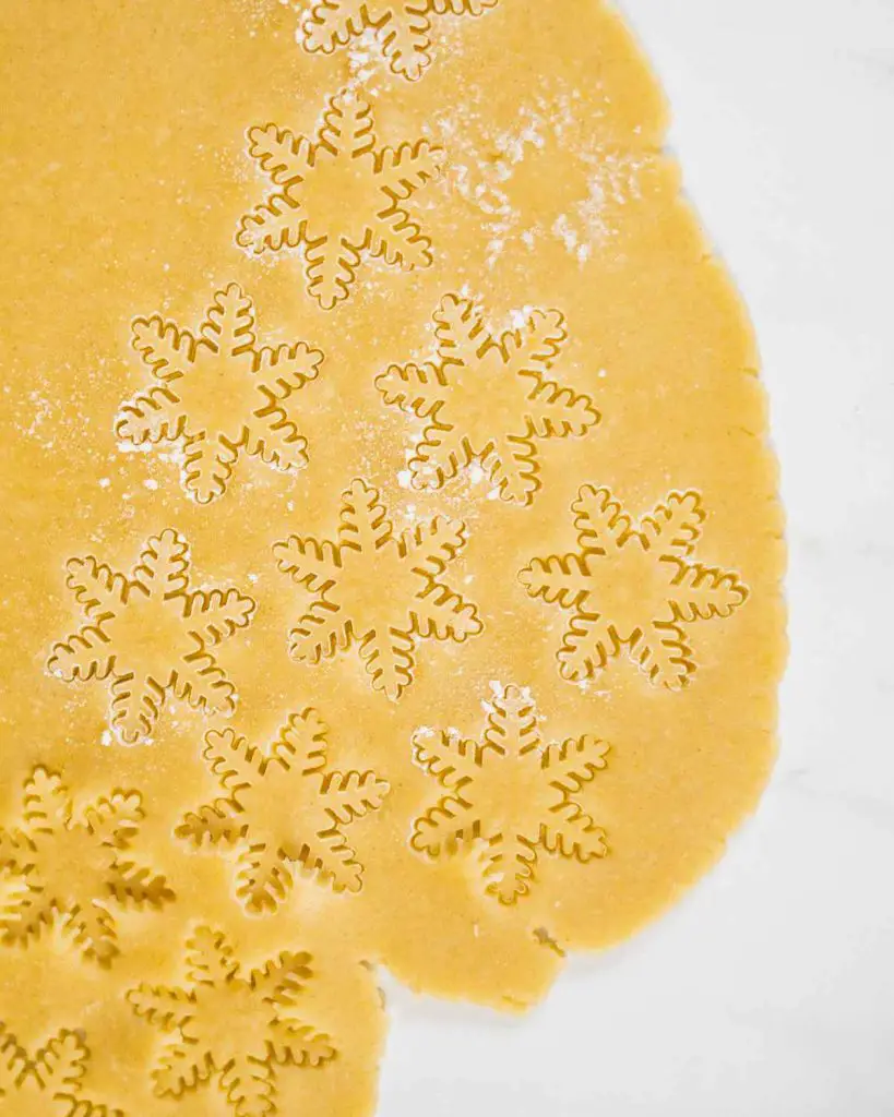 Stamping out snowflake pastry shapes to top the mini pies before baking. Recipe by movers and bakers