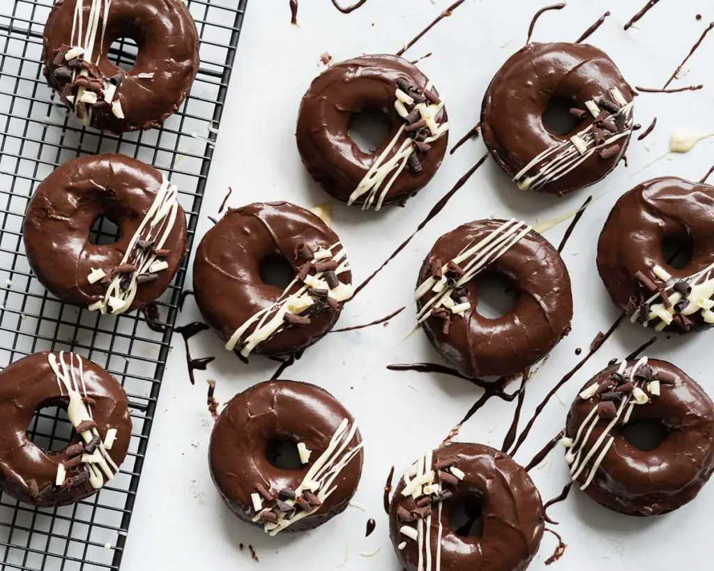 A chocaholic's dream doughnut: chocolate fudge doughnuts with all the chocolate trimmings! Recipe by movers and bakers