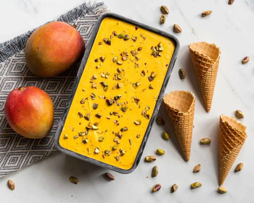 Mango kulfi. Creamy no churn mango ice cream with pistachio and cardamom makes the most heavenly summertime treat! Recipe by movers and bakers