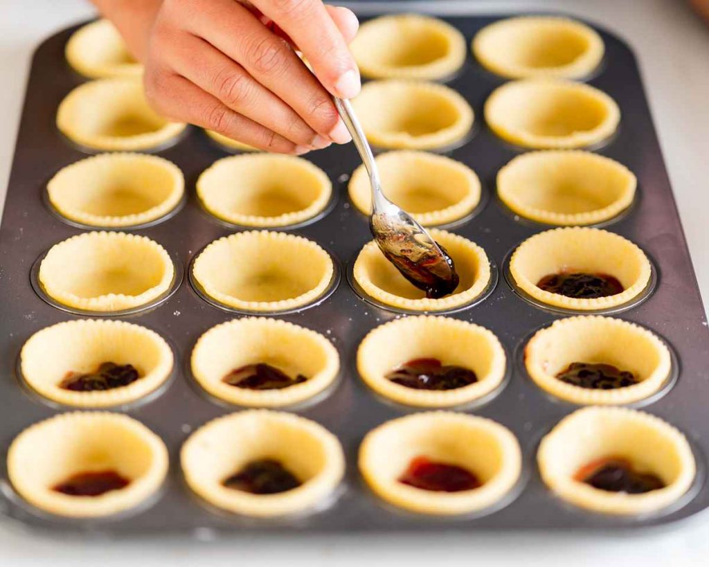 Filling the chilled pastry shells with cherry compote. Recipe by movers and bakers