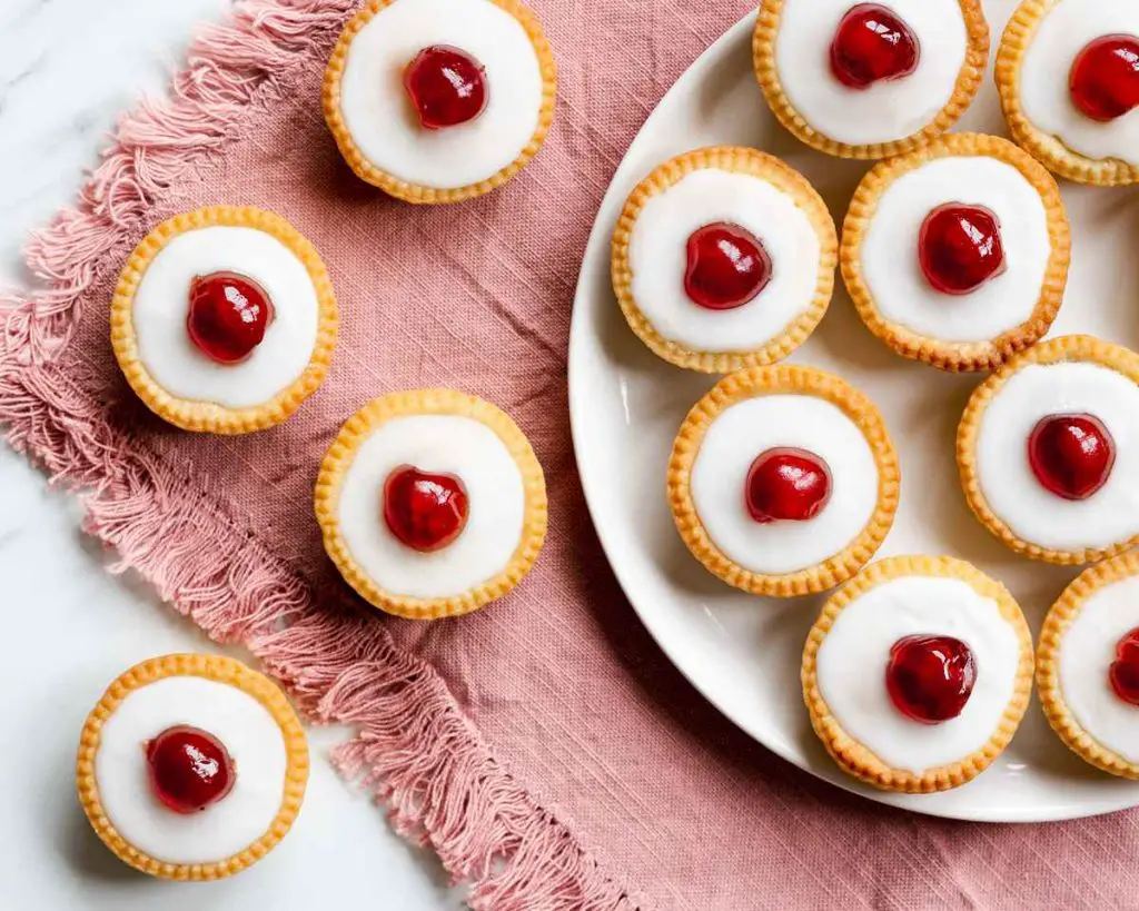 Cherry bakewell tartlets. Cherry and almond in a sweet shortcrust pastry topped with smooth icing and a glacé cherry half. Heaven! Recipe by movers and bakers