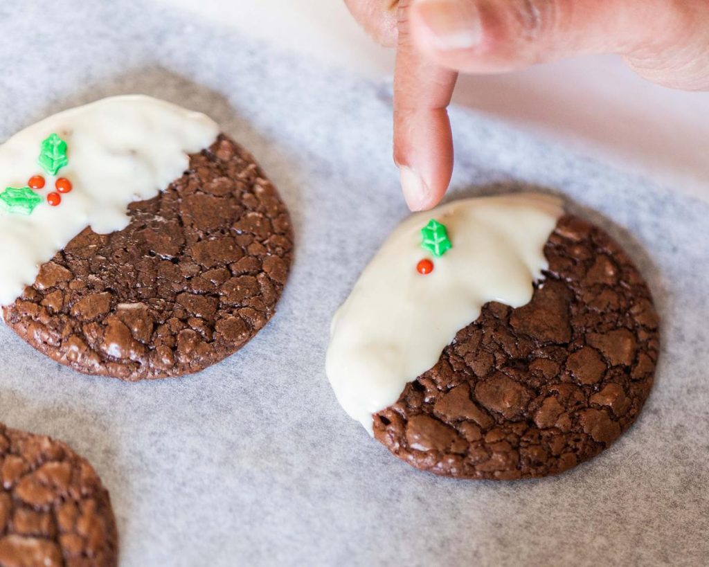 Adding the finishing touches to the Christmas pudding cookies. Recipe by movers and bakers