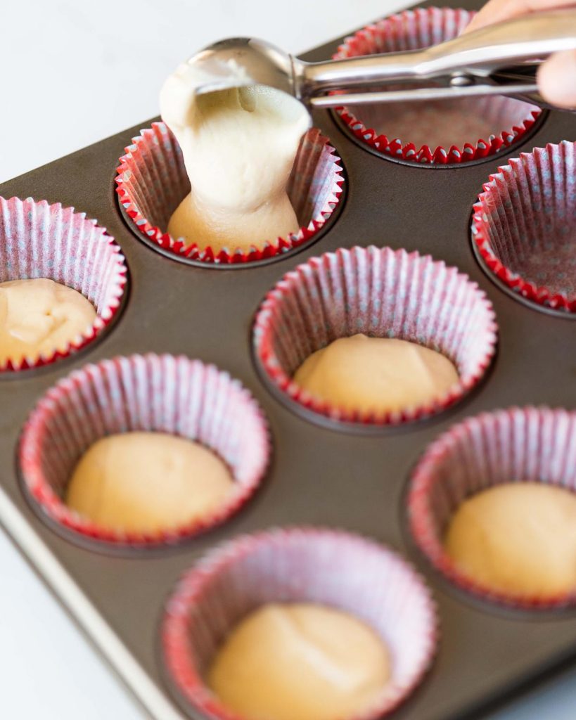 Scooping the cupcake mixture into the cases before baking. Recipe by movers and bakers