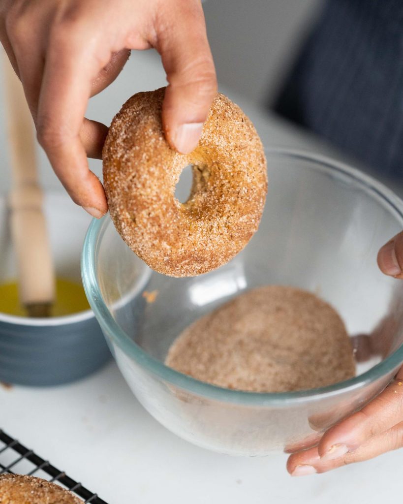After brushing with melted butter, the donuts are coated in a yummy cinnamon sugar #moversandbakers #egglessdonuts #cinnamonsugardonuts #recipeforegglessdonuts