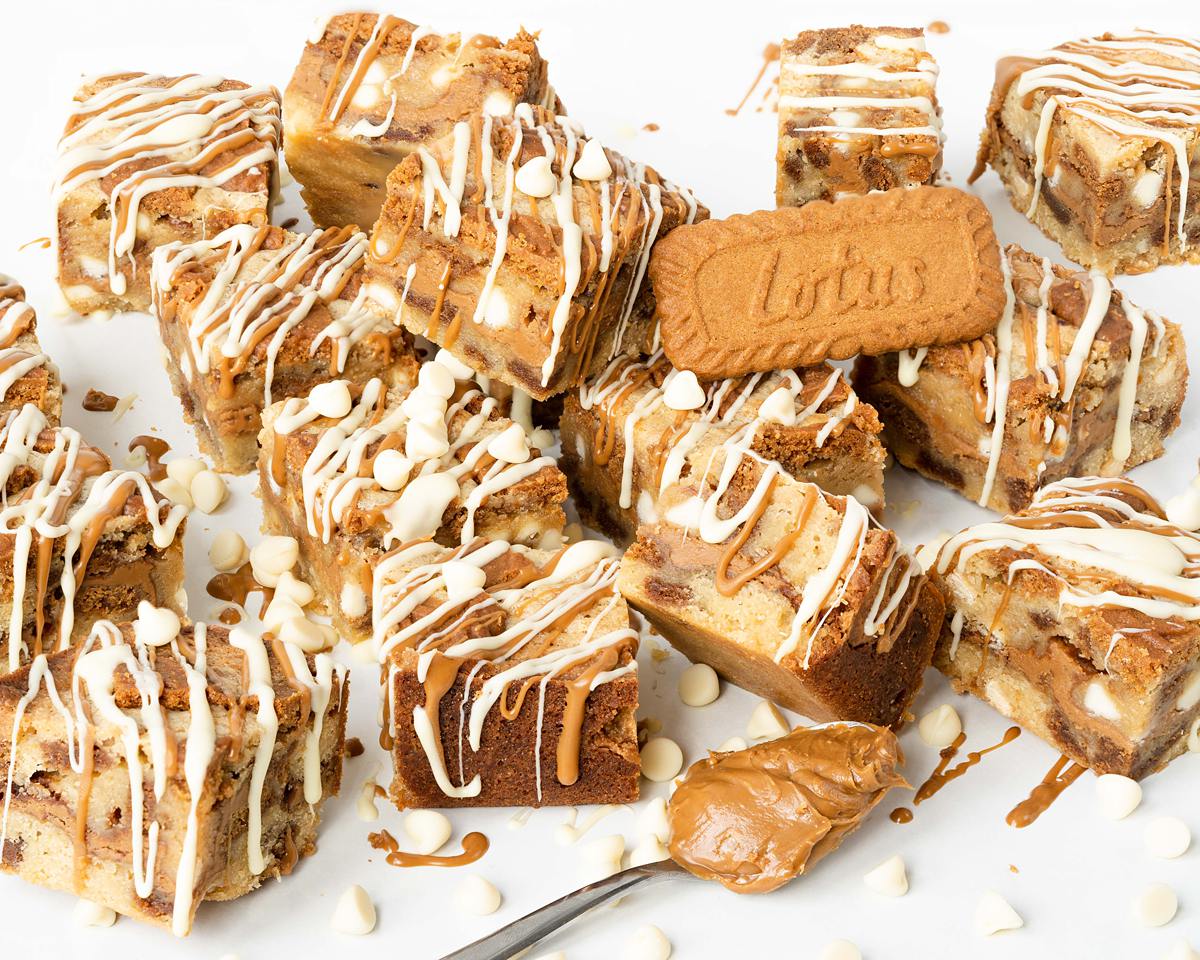 Ultra indulgent Biscoff blondies crammed full of Biscoff biscuits and spread and finished with a drizzle of Biscoff spread and white chocolate | Recipe from moversandbakers.co.uk