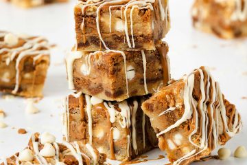 Ultra indulgent Biscoff blondies crammed full of Biscoff biscuits and spread and finished with a drizzle of Biscoff spread and white chocolate | Recipe from moversandbakers.co.uk