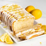 Vegan lemon drizzle loaf cake with two slices cut from it: light and fluffy and oh so lemony!