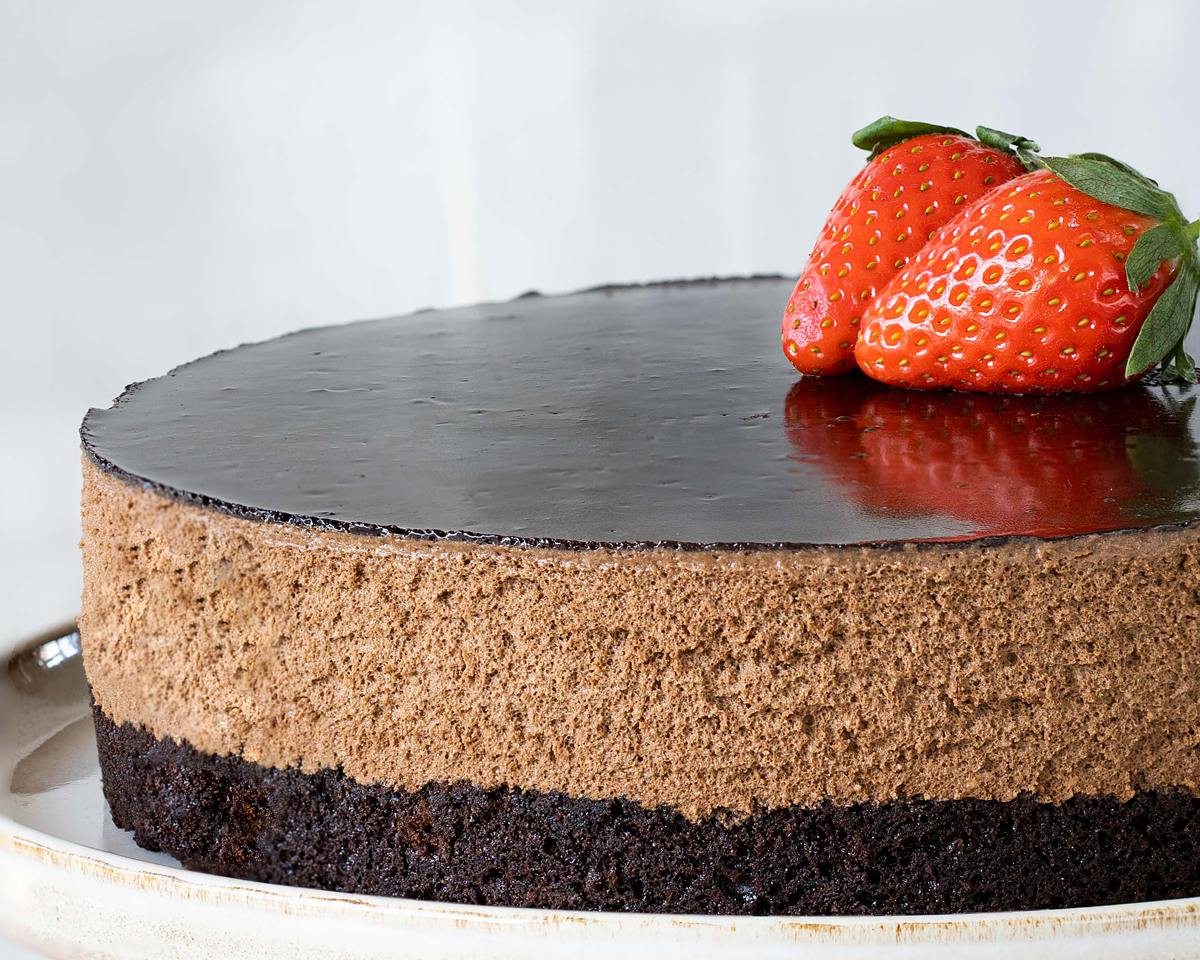 My brownie mousse cake has a beautiful soft brownie layer, a generous light and richly chocolatey mousse layer and a smooth shiny cocoa glaze. A perfect celebration cake for any occasion! Recipe by movers and bakers