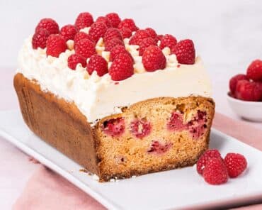 Raspberry and white chocolate loaf cake. A beautiful loaf cake packed with fresh tart raspberries and sweet white chocolate chips, topped with a white chocolate buttercream and more fresh raspberries. Recipe by movers and bakers