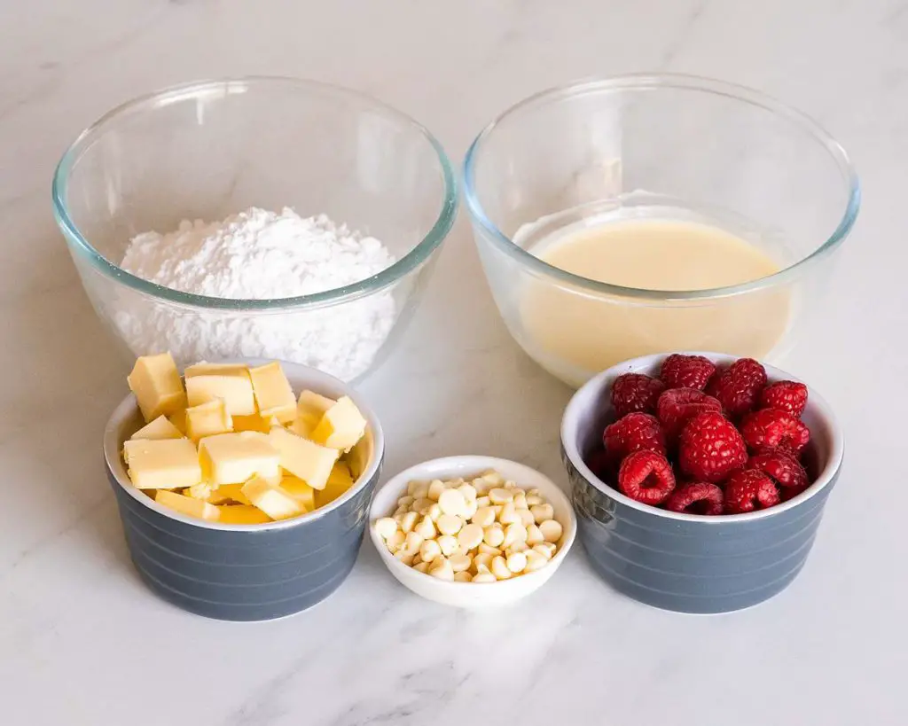 Icing and decoration ingredients: unsalted butter, icing sugar, melted white chocolate, fresh raspberries and white choc chips. Recipe by movers and bakers