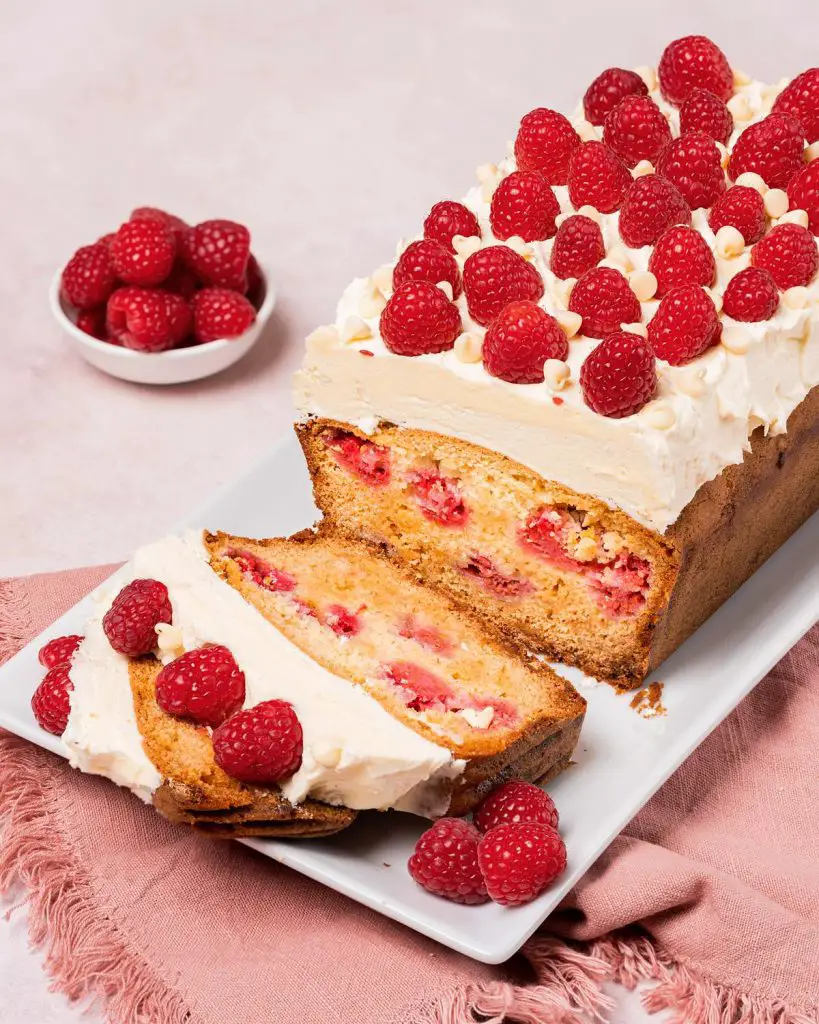 Raspberry and white chocolate loaf cake. A beautiful loaf cake packed with fresh tart raspberries and sweet white chocolate chips, topped with a white chocolate buttercream and more fresh raspberries. Recipe by movers and bakers