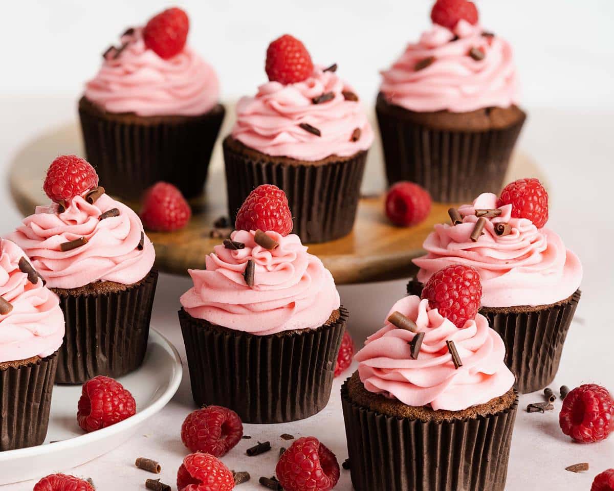 My chocolate raspberry cupcakes are delicious light and fluffy chocolate cupcakes topped with a tangy and sweet fresh raspberry buttercream. It is crowned with chocolate curls and a single raspberry to finish. Recipe by movers and bakers