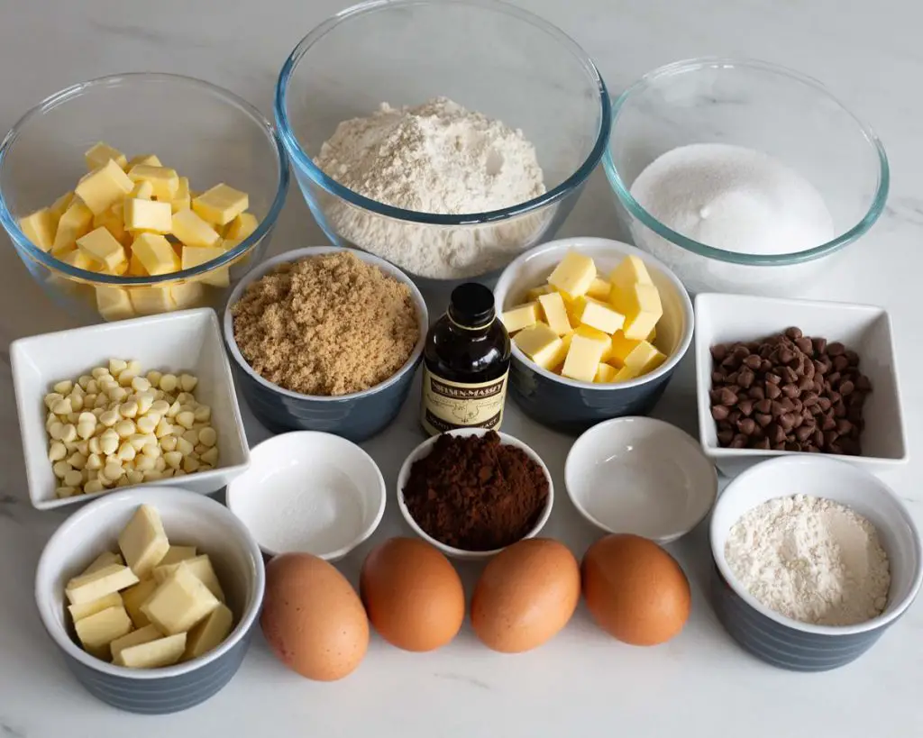 Ingredients needed for this bake: butter, caster sugar, brown sugar, eggs, vanilla, cocoa powder, flour, salt, white chocolate, milk chocolate chips and white chocolate chips. Recipe by movers and bakers