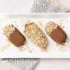 Peanut butter chocolate ice cream. Ice cream lollies made with creamy peanut butter ice cream dipped in a magic shell chocolate coating and topped with chopped peanuts. Recipe by movers and bakers