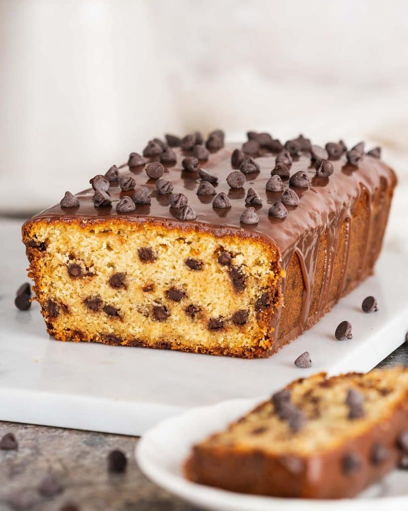 Chocolate chip loaf cake. Soft and moist vanilla cake, packed with chocolate chips in every bite, and a beautiful shiny chocolate ganache topping. Recipe by movers and bakers