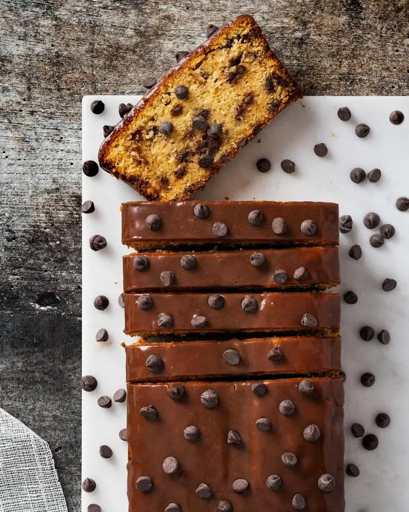 Chocolate chip loaf cake. Soft and moist vanilla cake, packed with chocolate chips in every bite, and a beautiful shiny chocolate ganache topping. Recipe by movers and bakers