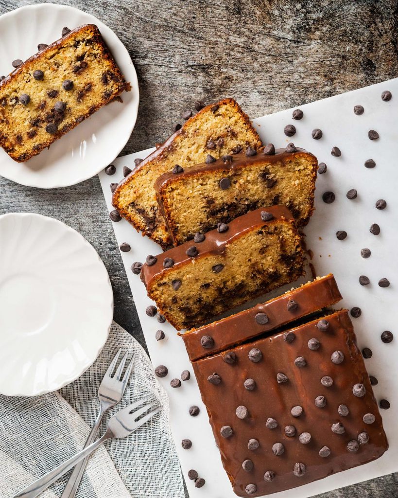 Chocolate chip loaf cake. Soft and moist vanilla cake, packed with chocolate chips in every bite, and a beautiful shiny chocolate ganache topping. Recipe by movers and bakers