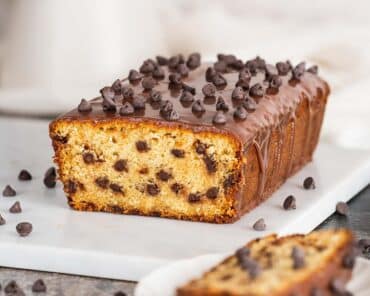 Chocolate chip loaf cake. Soft and moist vanilla cake, packed with chocolate chips in every bite, and a beautiful shiny chocolate ganache topping. Recipe by movers and bakers