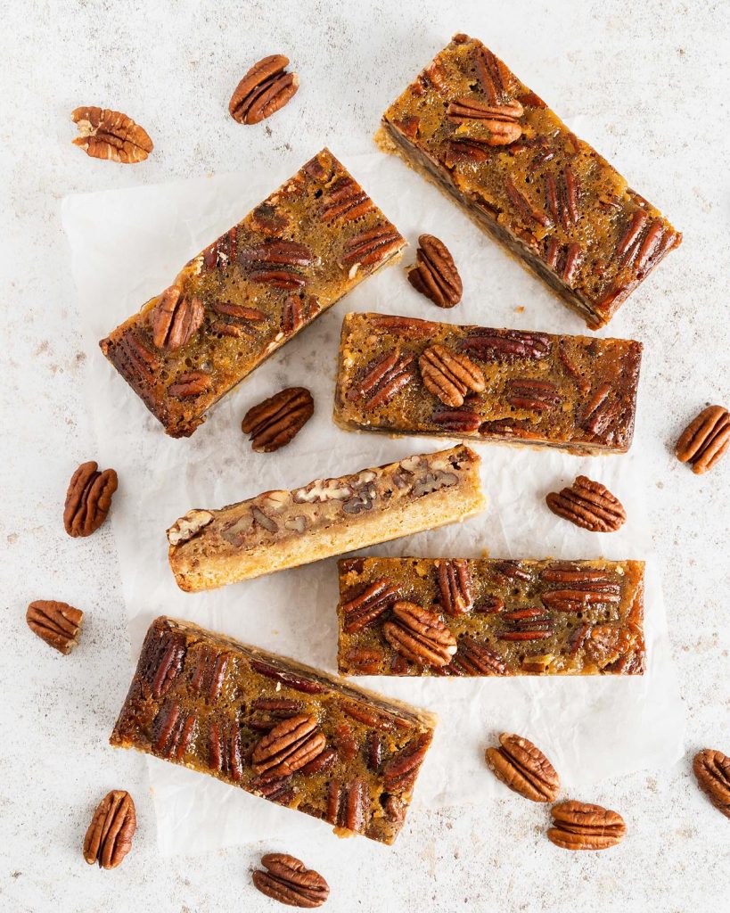 Maple pecan bars. A beautiful buttery brown sugar shortbread crust topped with a rich maple caramel filling and lots of pecans. A brilliant quick alternative to pecan pie! Recipe by movers and bakers