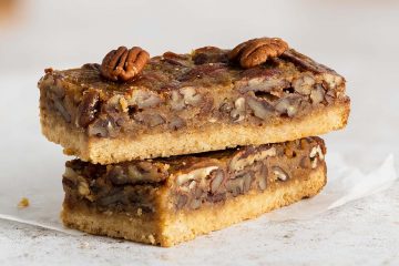 Maple pecan bars. A beautiful buttery brown sugar shortbread crust topped with a rich maple caramel filling and lots of pecans. A brilliant quick alternative to pecan pie! Recipe by movers and bakers