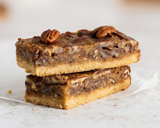 Maple pecan bars. A beautiful buttery brown sugar shortbread crust topped with a rich maple caramel filling and lots of pecans. A brilliant quick alternative to pecan pie! Recipe by movers and bakers
