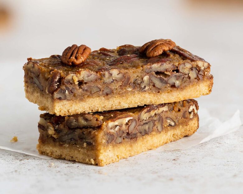 Maple pecan bars. A beautiful buttery brown sugar shortbread crust topped with a rich maple caramel filling and lots of pecans. A brilliant quick alternative to pecan pie! Recipe by movers and bakers