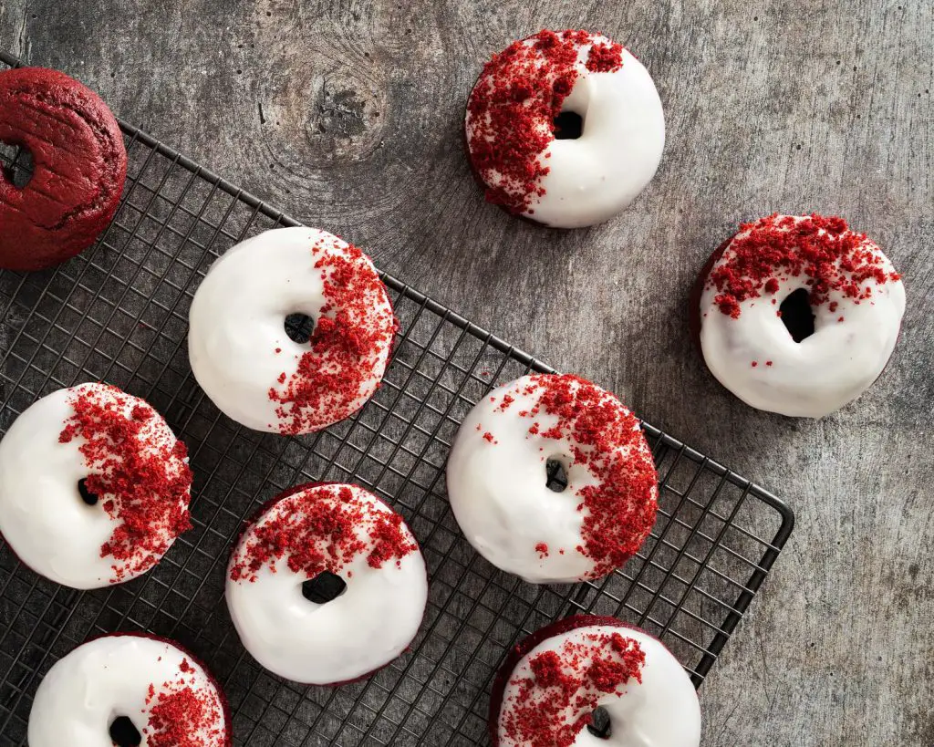 Red velvet donuts. Light and fluffy red velvet donuts, topped with a glorious cream cheese glaze and red velvet cake crumbs. Recipe by movers and bakers