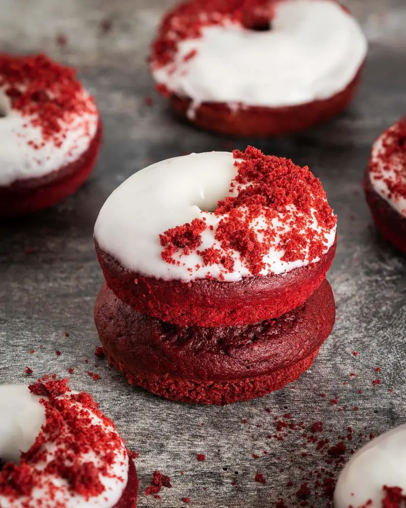 Red velvet donuts. Light and fluffy red velvet donuts, topped with a glorious cream cheese glaze and red velvet cake crumbs. Recipe by movers and bakers
