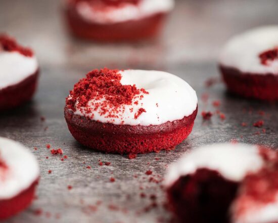Red velvet donuts. Light and fluffy red velvet donuts, topped with a glorious cream cheese glaze and red velvet cake crumbs. Recipe by movers and bakers
