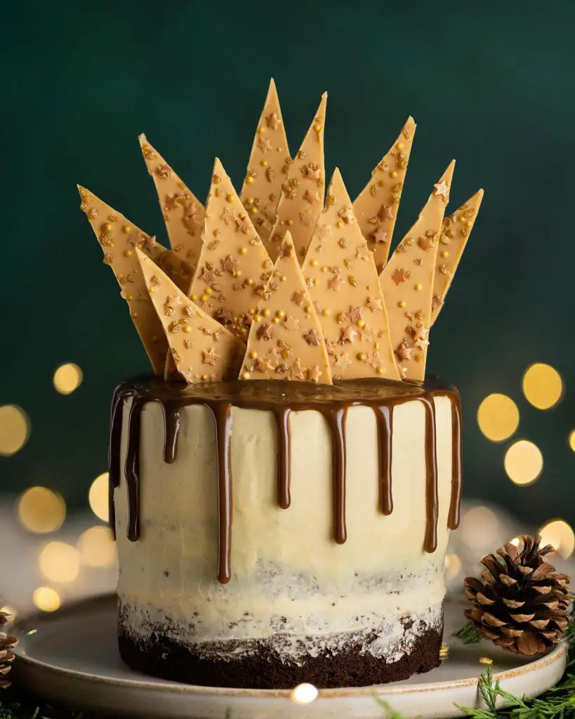 Sticky toffee pudding cake. Three layers of rich date sponge cake, sandwiched together with caramelised white chocolate buttercream, toffee drip and caramelised white chocolate shard topping. Recipe by movers and bakers