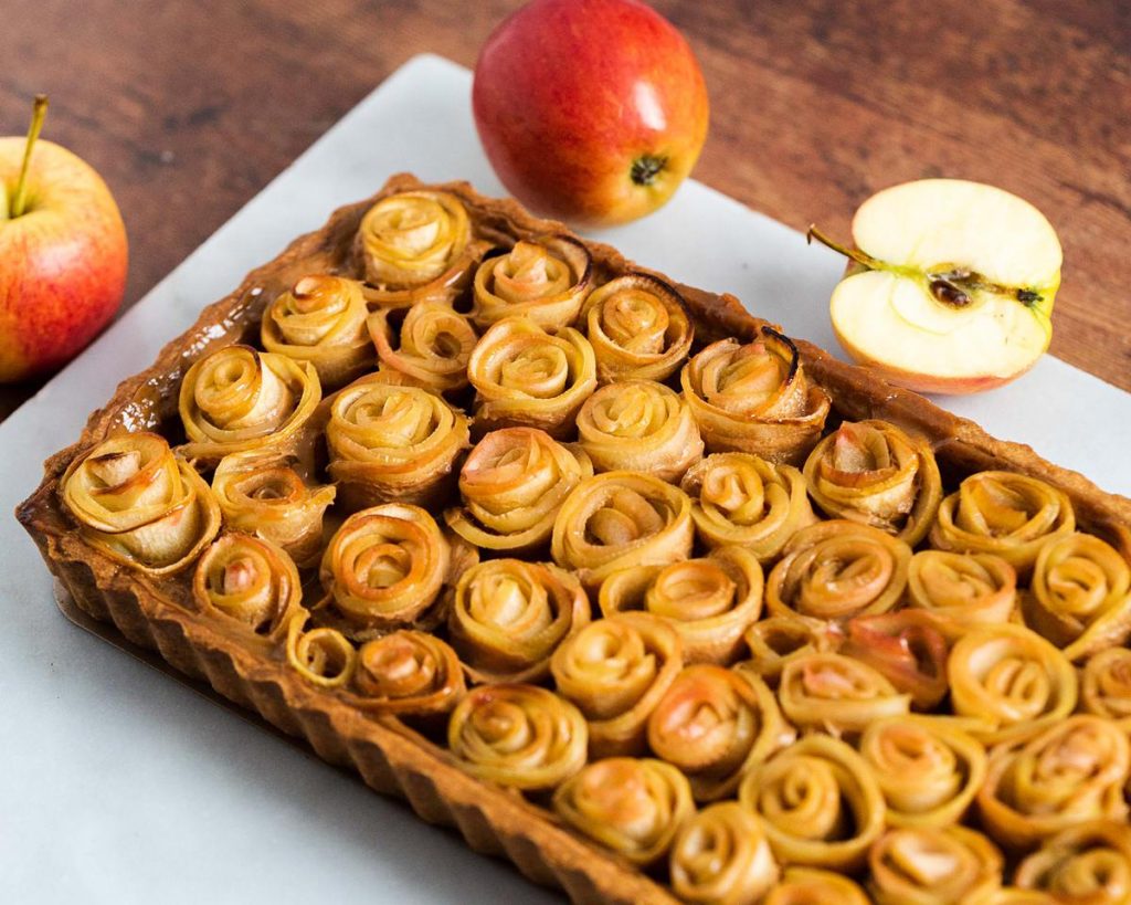 Caramel apple tart. A buttery shortbread pastry base, filled with rich caramel and topped with beautiful apple roses. Recipe by movers and bakers