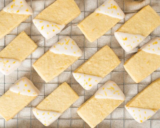 Lemon shortbread cookies. Beautiful, buttery shortbread cookies, packed with zingy lemon flavour are dipped in a bright lemon glaze and sprinkled with more lemon zest for all the luscious lemon flavour! Recipe by movers and bakers
