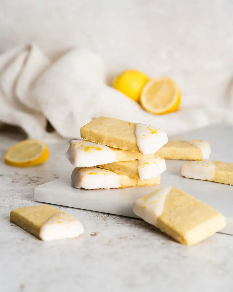 Lemon shortbread cookies. Beautiful, buttery shortbread cookies, packed with zingy lemon flavour are dipped in a bright lemon glaze and sprinkled with more lemon zest for all the luscious lemon flavour! Recipe by movers and bakers