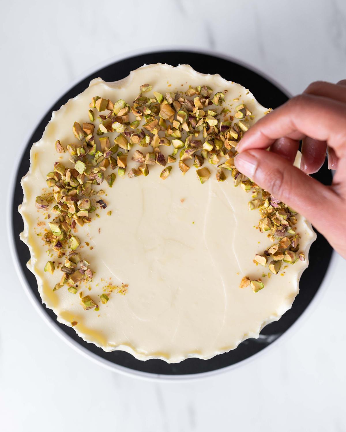 Sprinkling pistachios to decorate the top of the cake....