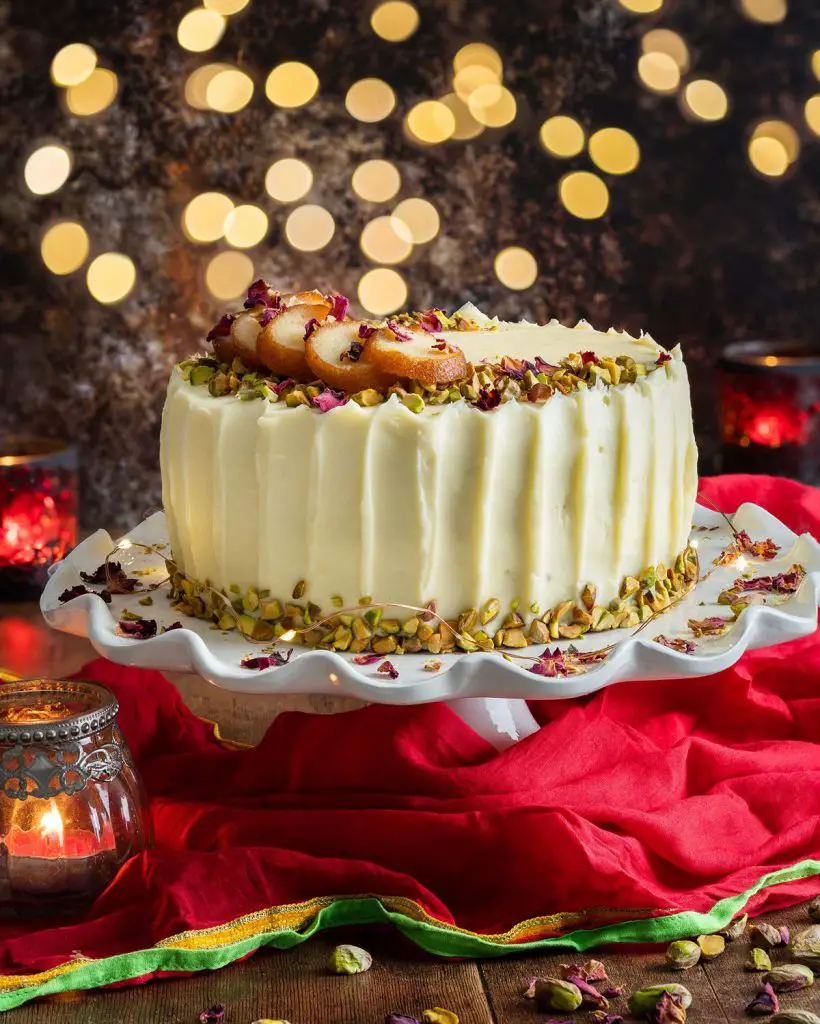 Pistachio cardamom cake. Two layers of eggless pistachio cake with aromatic cardamom, filled and decorated with an incredible cream cheese icing and more pistachio nuts. Garnish with slices of gulab jamun and some rose petals for a stunning celebration cake! Recipe by movers and bakers