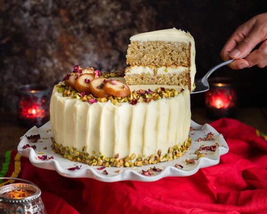 Pistachio cardamom cake. Two layers of eggless pistachio cake with aromatic cardamom, filled and decorated with an incredible cream cheese icing and more pistachio nuts. Garnish with slices of gulab jamun and some rose petals for a stunning celebration cake! Recipe by movers and bakers