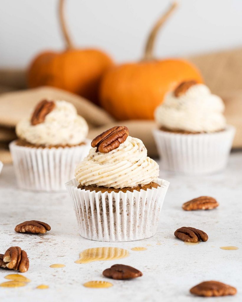 Pumpkin Spice Cupcakes. These delicious, warming pumpkin cupcakes are so light and fluffy, and are topped with the most incredible maple pecan buttercream! A perfect autumnal bake! Recipe by movers and bakers #pumpkinspicecupcakes #pumpkinspice #autumnbaking #pumpkincupcakes 