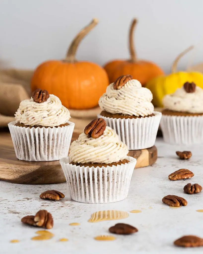 Pumpkin Spice Cupcakes. These delicious, warming pumpkin cupcakes are so light and fluffy, and are topped with the most incredible maple pecan buttercream! A perfect autumnal bake! Recipe by movers and bakers #pumpkinspicecupcakes #pumpkinspice #autumnbaking #pumpkincupcakes 
