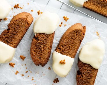 Gingerbread biscotti. Warmly spiced, crunchy biscotti dipped in smooth and creamy white chocolate. The perfect festive cookie for gifting or to enjoy with a hot drink! Recipe by movers and bakers