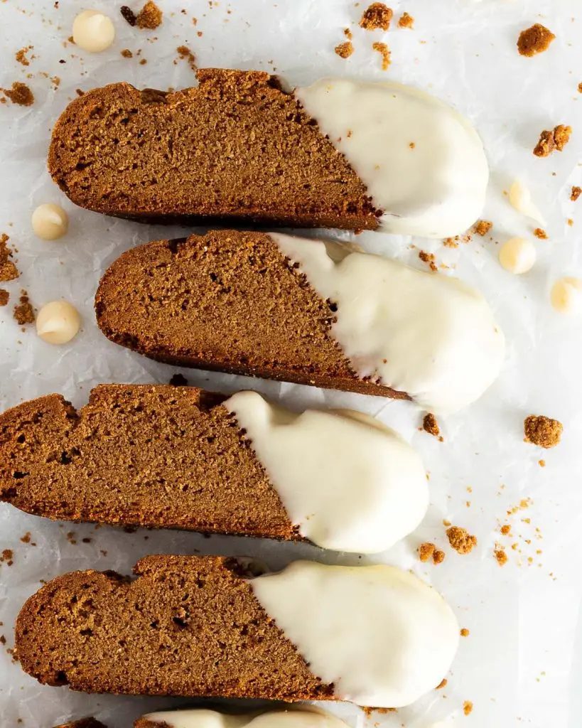 Gingerbread biscotti. Warmly spiced, crunchy biscotti dipped in smooth and creamy white chocolate. The perfect festive cookie for gifting or to enjoy with a hot drink! Recipe by movers and bakers