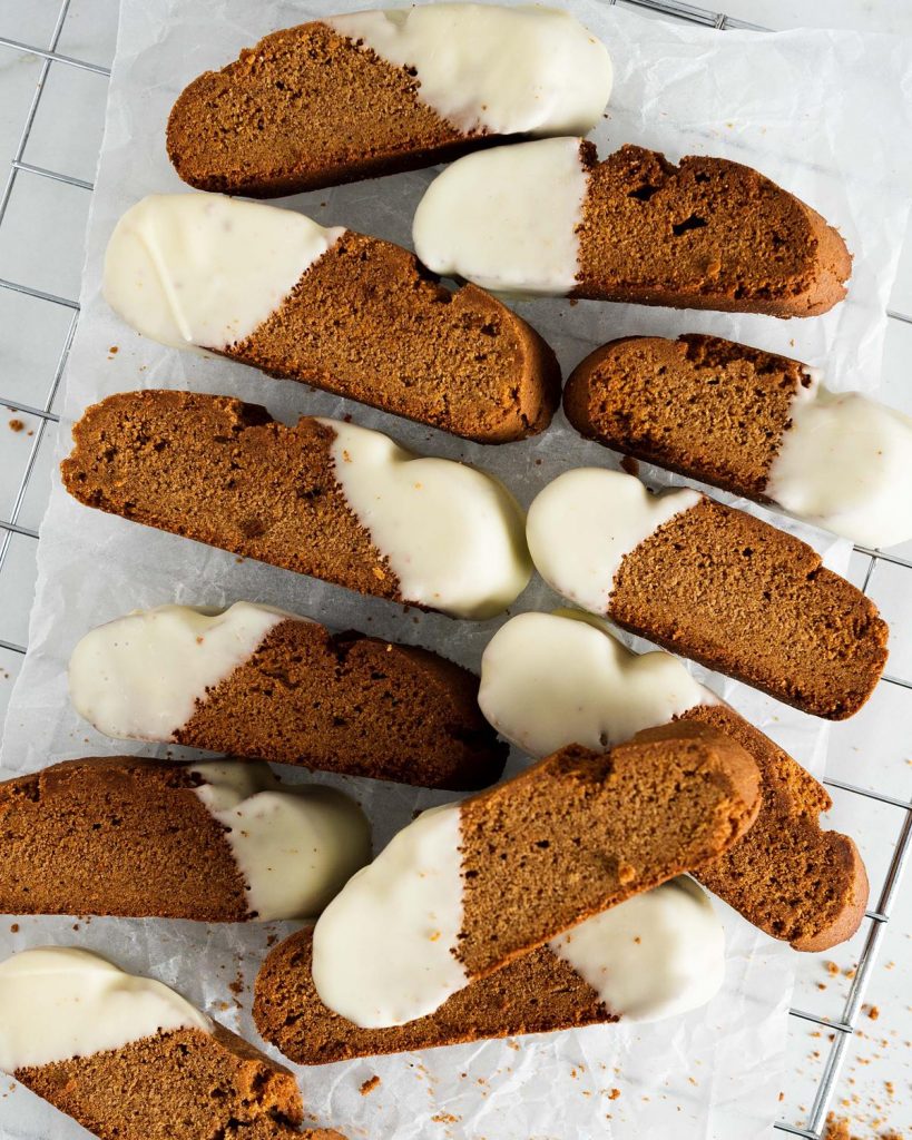 Gingerbread biscotti. Warmly spiced, crunchy biscotti dipped in smooth and creamy white chocolate. The perfect festive cookie for gifting or to enjoy with a hot drink! Recipe by movers and bakers
