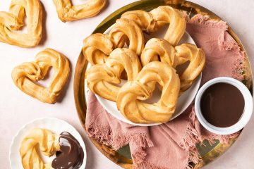 Churros with chocolate sauce. These heart shaped churros are a perfect Valentine's dessert, or just to share with loved ones any time! Churros served with a wonderful rich chocolate fudge sauce makes this an indulgent dessert everyone loves! Recipe by movers and bakers