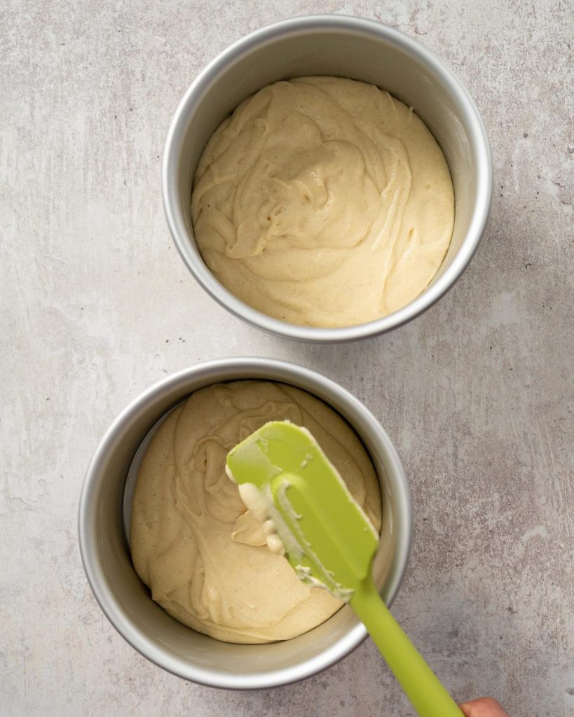 Divide the cake mixture between the prepared tins before baking. Recipe by movers and bakers