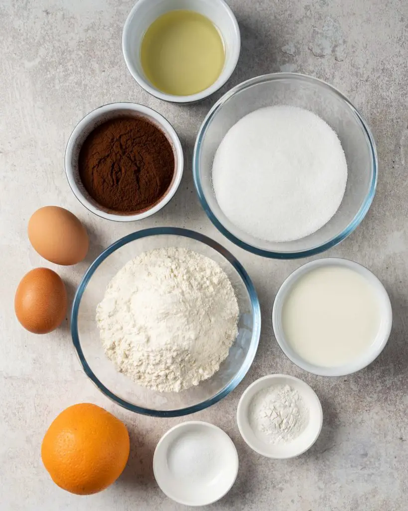 Ingredients required for the cake: plain (all purpose) flour, caster sugar, cocoa powder, baking powder, salt, eggs, buttermilk, oil, boiling water, orange juice and zest. Recipe by movers and bakers