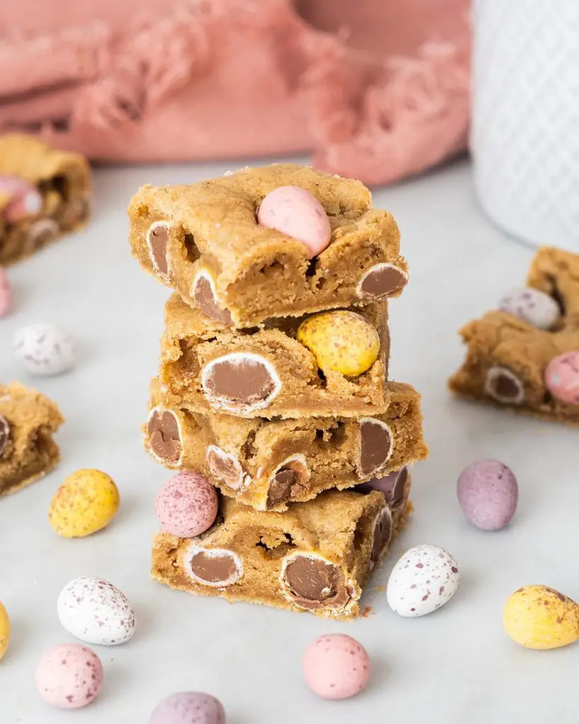 Mini egg cookie bars. Soft and chewy brown butter cookie bars packed with Cadburys mini eggs make this an Easter bake everyone will love! Recipe by movers and bakers