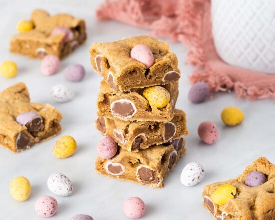 Mini egg cookie bars. Soft and chewy brown butter cookie bars packed with Cadburys mini eggs make this an Easter bake everyone will love! Recipe by movers and bakers